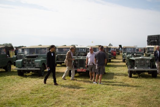 A field of classic Land Rover Defenders going back as far as the eye can see.