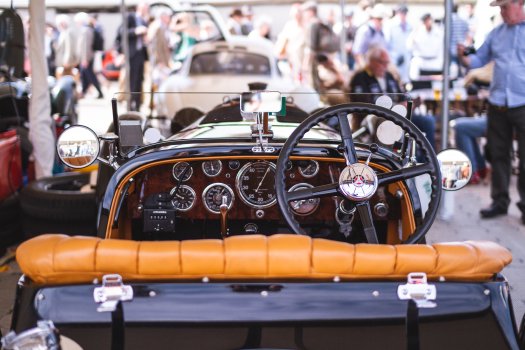 A view of the controls of a very old car, all big dials and chrome.