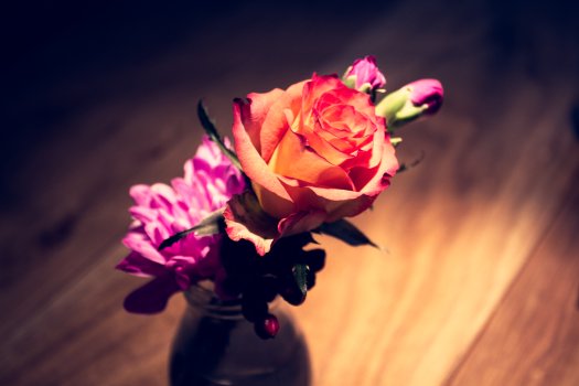 A set of wilting roses in a glass vase.