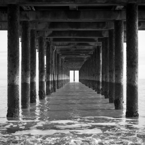 The view under a pier, looking out to sea