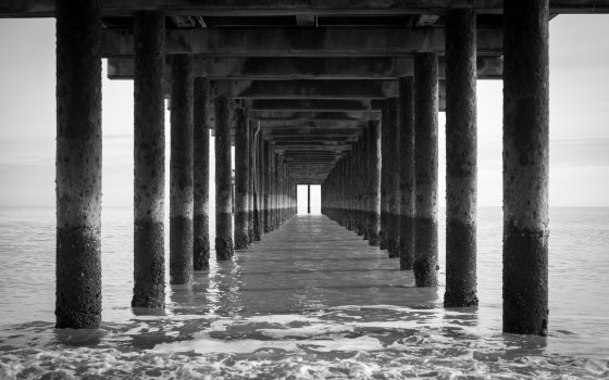 The view under a pier, looking out to sea