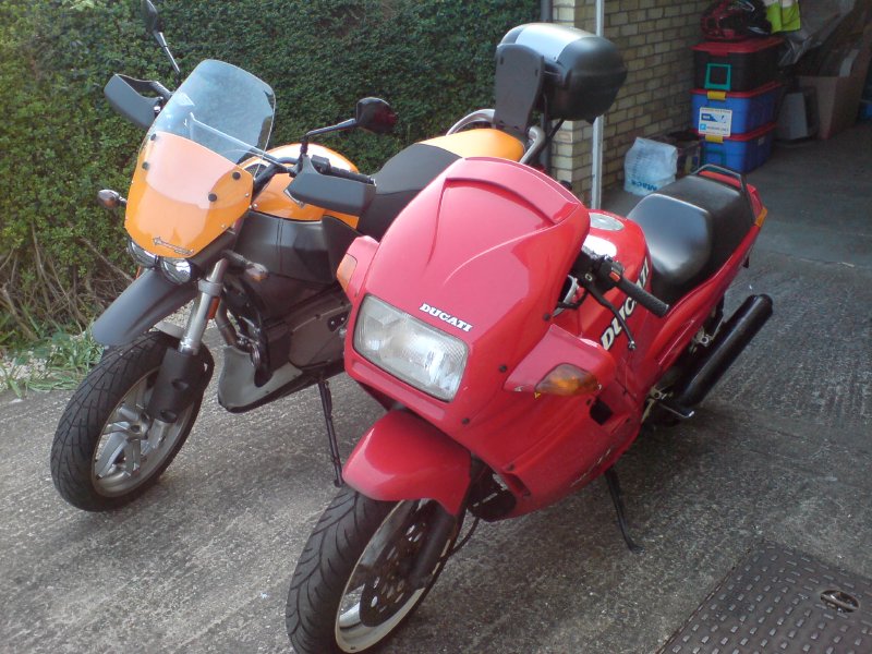 The old red Ducati that is going away stood next to the orange Buell Ulysses that replaces it