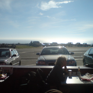 A picture from a cafe next to the road, looking across the road to the pacific ocean.
