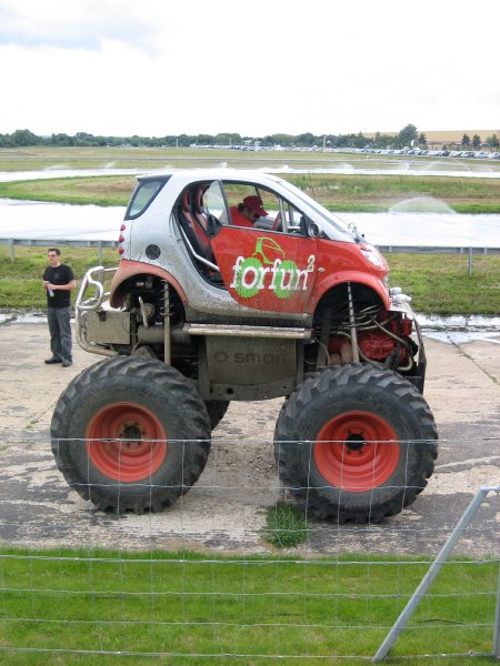 A monster smart fortwo car with wheels the size of the car itself.