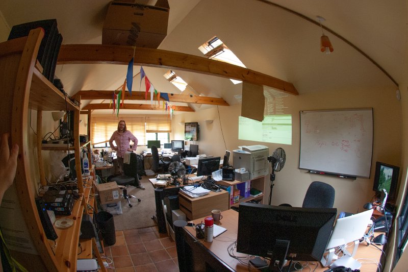 A photo of me in a summer house filled with computers, desks, and bunting.