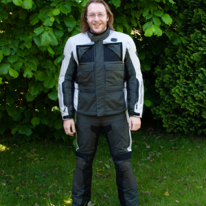 A photo of me stood in a garden wearing a set of adventure motorcycling gear."