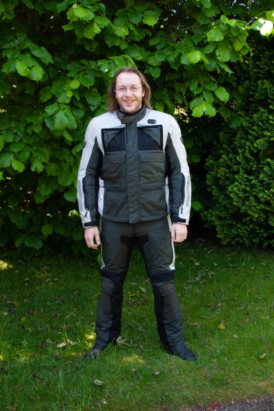A photo of me stood in a garden wearing a set of adventure motorcycling gear.