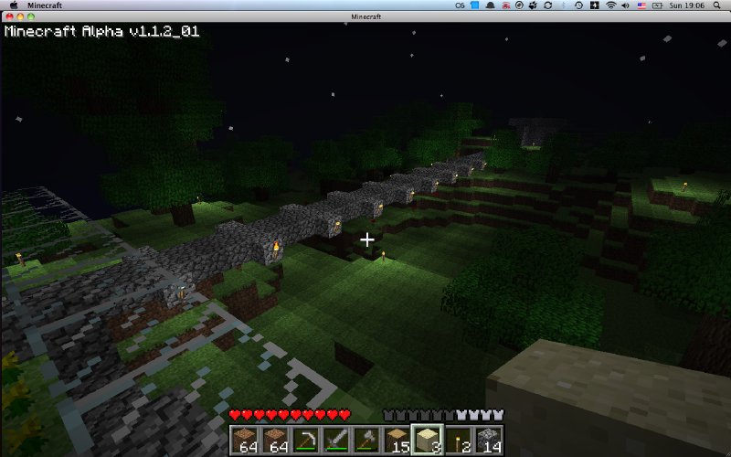 A screenshot of minecraft, showing a crudely made cobblestone bridge at night