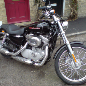 A classic Harley Davidson chopper parked on a residential street"