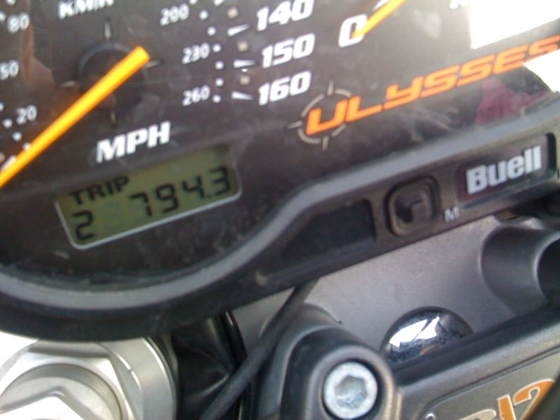 A close up on the bike's dashboard, showing a tripometer readout of 794.3 miles.