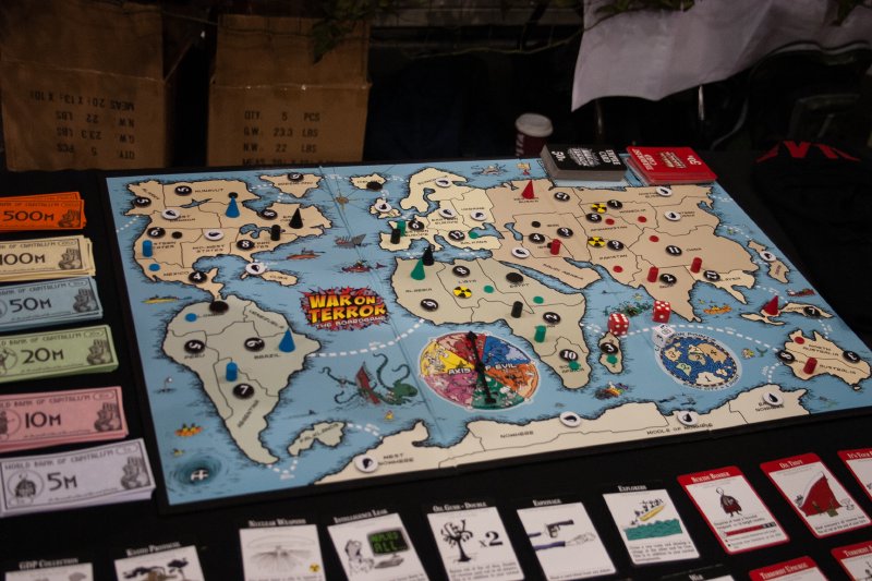 A photo of what looks like a regular board game, with cards and paper money beside it. The board shows a crude map of the world and has 'war on terror' written on it.