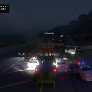A screenshot from GTA V showing a digger driving down a road with police trying to blockade it and someone riding in the digger's scoop.