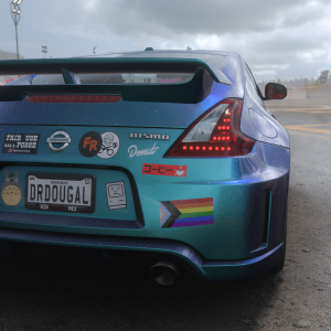 A screenshot of a Nissan 370Z car in Forza Horizon 5, showing the rear of the car is covered in bumper stickers. There are a lot: a LBGTQ+ flag, an EFF sticker, a Totoro, a sad classic mac, "caution: slow moving vehicle", a donut media sticker, a FailRace logo, a Pistonheads logo, and a lo car sticker.