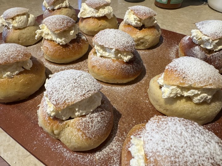 Tolv fräsch semlor på en skärbräda.