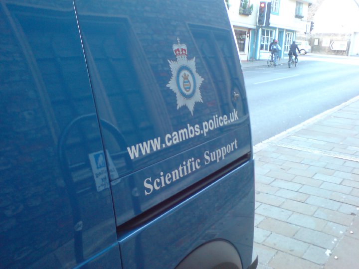 The side of a van parked on a Cambridge street, which reads 'www.cambs.police.uk Scientific Support'