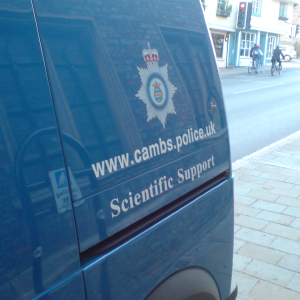 The side of a van parked on a Cambridge street, which reads 'www.cambs.police.uk Scientific Support'