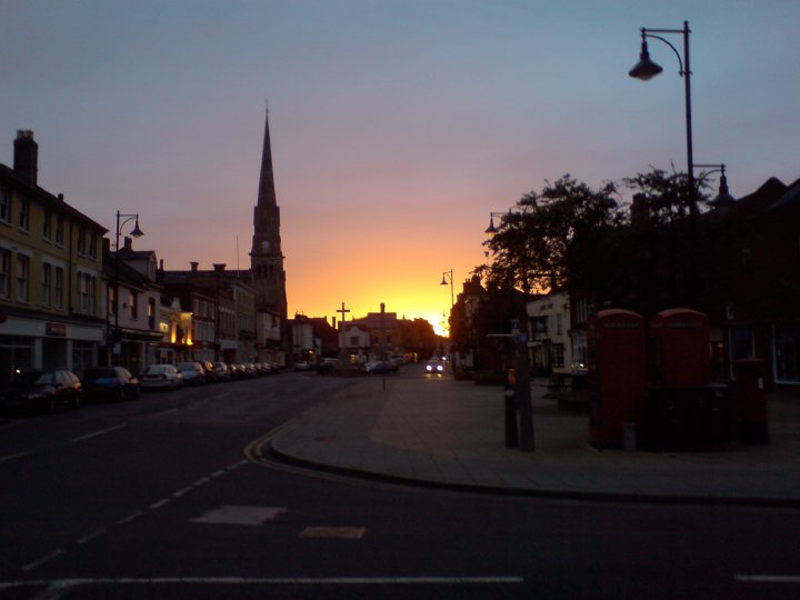 A glowing sunset lights the skyline, leaving St Ives main street in shadow.