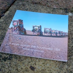 A photo of the cover of the zine, the famous cadillac graveyard, consiting of a doze cadillac cars half-burried nose down in the hard soil.